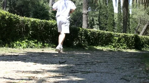 Aged man jogging in the park Stock Footage 11232858