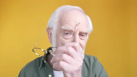 Aged man look in camera with specs isolated shine color background Stock Footage 196089085