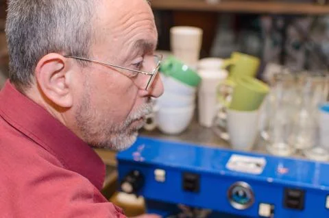 Aged man making coffee Stock Photos