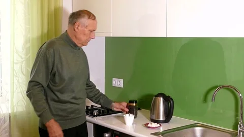 Aged man making tea on the kitchen at home Video stock 71885394