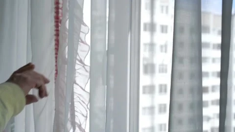 Aged man in mask comes to window opens curtains waves hand Stock Footage 134998292