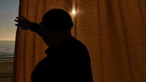 Aged man opens a large curtain with sea beach view silhouette Stock-Footage 89656469