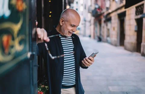 Aged man with smartphone tech using 4g internet for messaging and chatting in Stock Photos