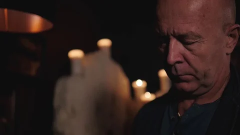 An aged man is thinking over something and looking down. Close up. Stock Footage 120486851