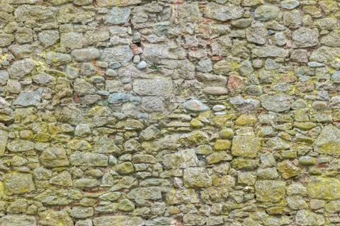Aged or ancient yellow bricks and stones wall. Seamless brick background Stock Photos