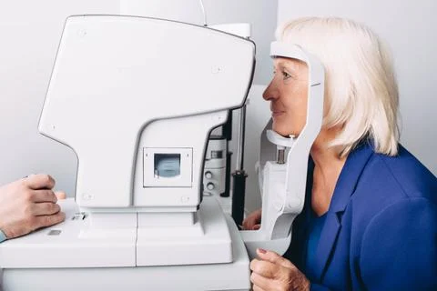 Aged patient doing eye test with eye equipment Fotos de archivo