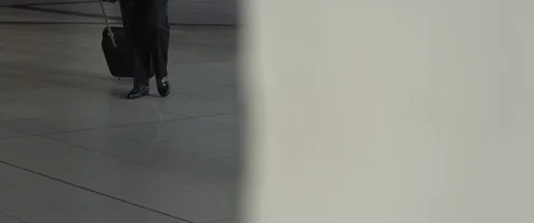 Aged pilot with Luggage or suitcase walks through airport terminal in daytime Stock Footage 120341253
