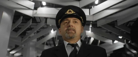 Aged pilot in uniform and cap walking by airport terminal and touching his tie Stock Footage 120341531
