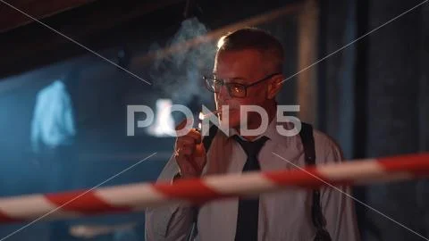 Aged police officer smoking cigarette at crime scene ~ Hi Res #224951858