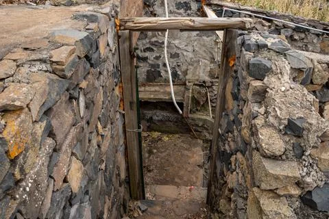 An aged stone structure featuring a dark, mysterious entrance. A mood of expl Stock Photos