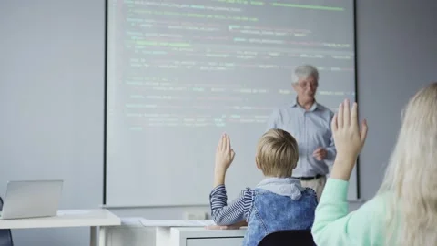 Aged teacher explaining lesson to children showing computer code Stock Footage 142492680