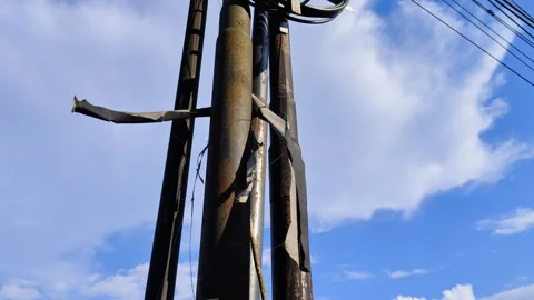 Aged Utility Pole with Damaged Wiring Against a Clear Blue Sky Video stock 309842614