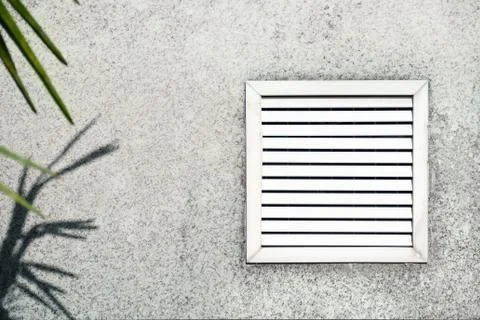 Aged vent with white shutters on the background of gray concrete. Stock Photos