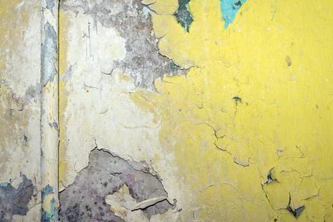 Aged wall texture with peeling paint layers in yellow and beige tones closeup Fotos de archivo