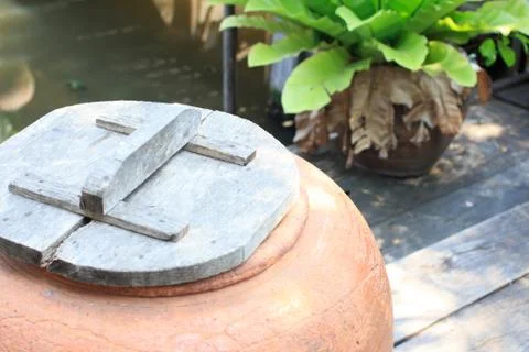 Aged water earthen jar in the garden Stock Photos