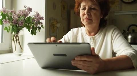Aged woman using a digital tablet PC at home Stock Footage 50593625