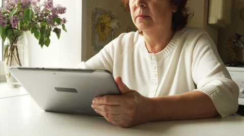 Aged woman using a digital tablet PC at home (tracking) Vídeo Stock 50593672