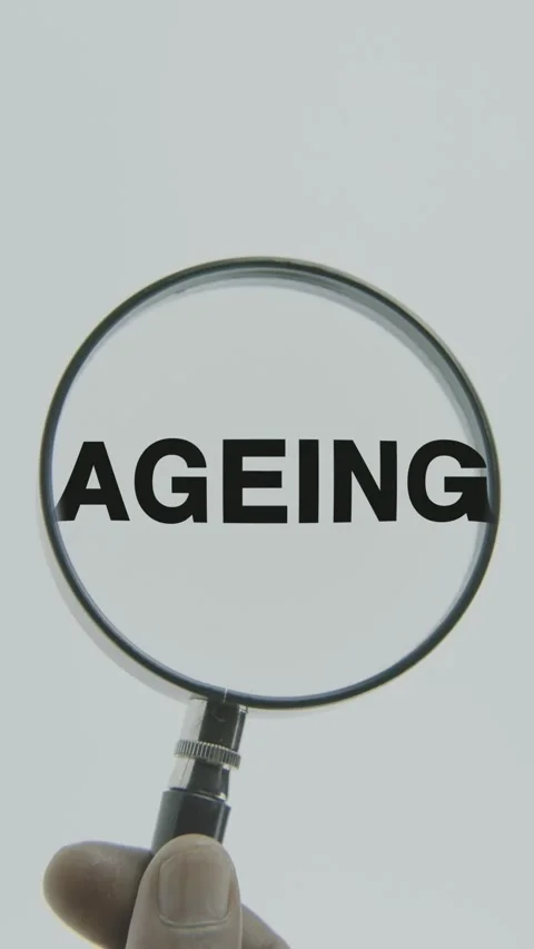 Ageing text or word highlighted by a magnifying glass in a hand on a white Stock Footage 303404989
