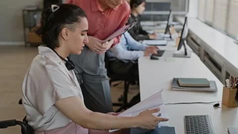 Agent with Disability Communicating with Colleague in Call Center Office Stock Footage 335749038