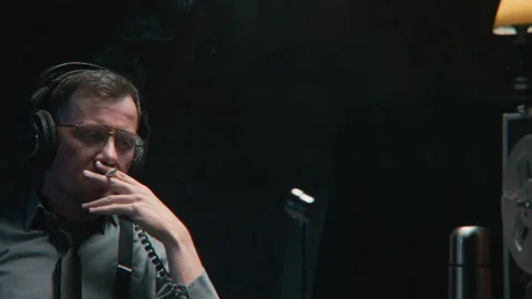 An agent engaged in wire tapping and smoking Stock-Footage 258227753