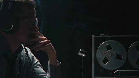 An agent smoking while wire tapping in the office 库存影片 258221307