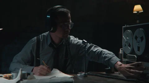 Agent using the wire tapping device and wearing headphones 库存影片 258168436