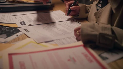 Agents or detectives reviewing and discuss classified documents, desk 스톡 동영상 311799391