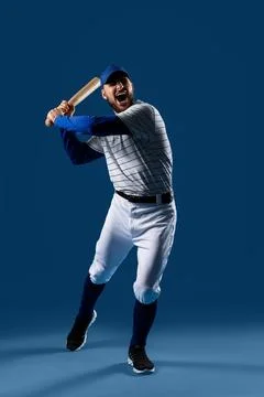 Aggressive baseball player swinging bat with intense expression, sports compe Stock Photos
