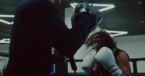 Aggressive black man is training in boxing center with coach, practicing punches Stock Footage 203814307