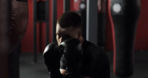 Aggressive boxer young man in gloves boxing and looking at camera in gym. Stock Footage 126822156
