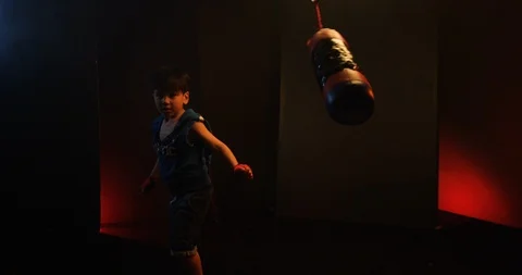Aggressive boy hitting the punching bag in gym Video stock 112078282