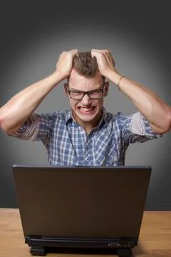 Aggressive boy sitting at the computer Stock Photos