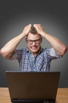 Aggressive boy sitting at the computer Stock Photos