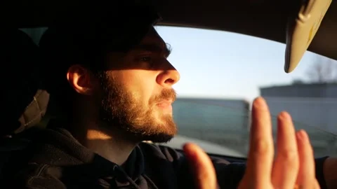 Aggressive driver behind the wheel. Young bearded man swears at the wheel Stock Footage 144555088