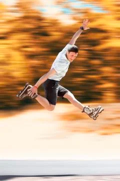 Aggressive inline skating. Young athlete performs tricks during freestyle rol Stock Photos