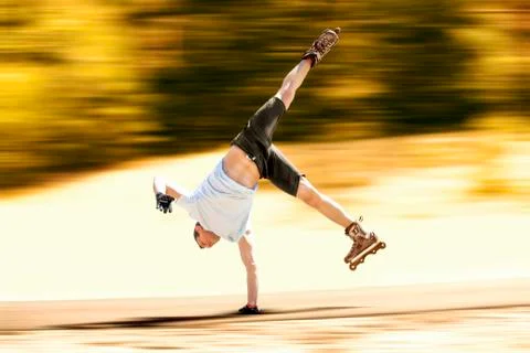 Aggressive inline skating. Young athlete performs tricks during freestyle rol Stock Photos