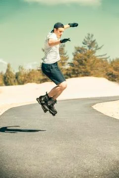 Aggressive inline skating. Young athlete performs tricks during freestyle rol Stock Photos