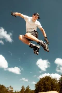 Aggressive inline skating. Young athlete performs tricks during freestyle rol Stock Photos