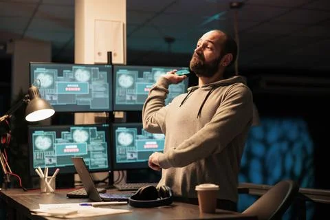 Aggressive male hacker throwing mouse in office Foto stock