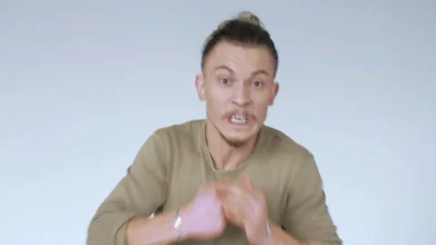 An aggressive man threatens to attack. Guy in a rage. Furious hipster. Stock Footage 141581116