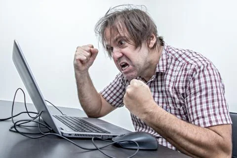 Aggressive man working with notebook at office. Stock Photos