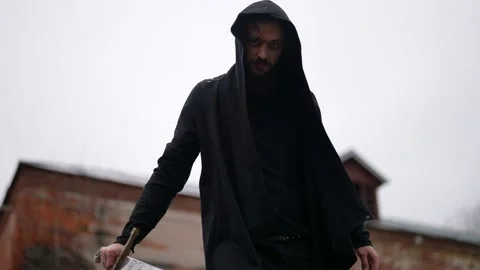 Aggressive mysterious man with sword is looking at camera, medieval warrior or Vídeos de archivo 179841448