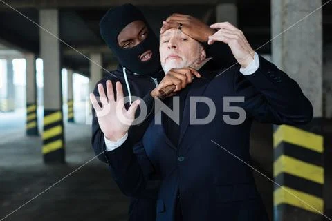 Aggressive ruthless criminal killing a man Stock Photos