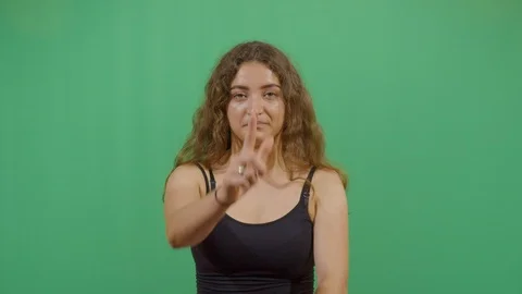 Aggressive woman executing the viewer with the hand in shape of a gun studio Stock Footage 117712824