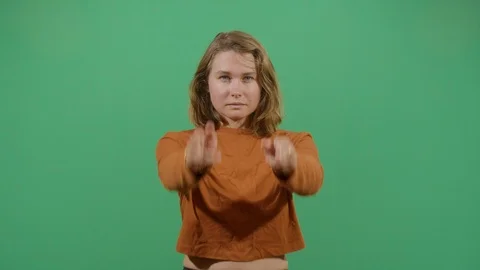 Aggressive woman executing the viewer with the hand in shape of a gun studio Stock Footage 117979519