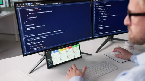 Agile Developer Checking Kanban Board On Secondary Screen While Writing Code Stock Footage 328403869
