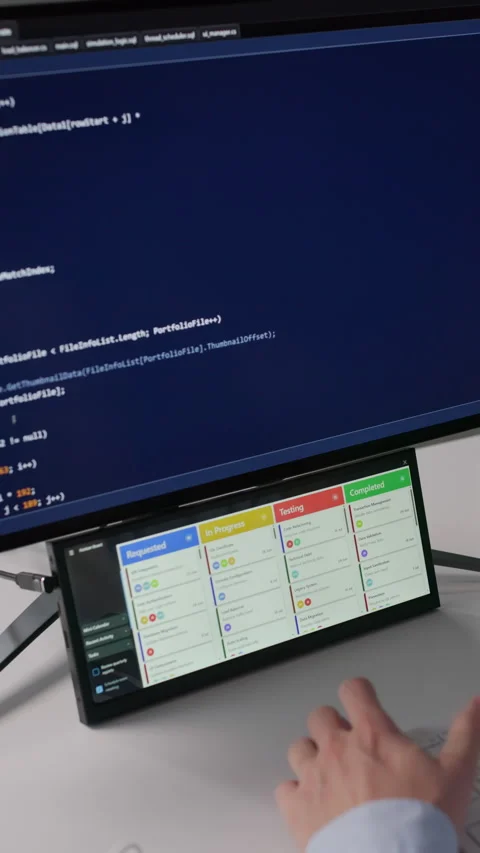 Agile Developer Checking Kanban Board On Secondary Screen While Writing Code Stock Footage 328404253