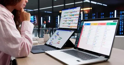 Agile Manager Carefully Plans Project Tasks Using Dual Screens In Office. Stock Photos