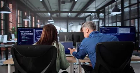 Agile Pair Programming: Senior Coder Coaching Woman In Classroom Stock-Fotos