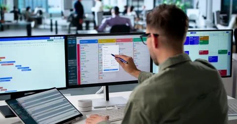 Agile Project Manager Studies Digital Scrum Board Tasks On Laptop Screen. Stock Photos